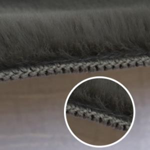 Close up of the sewn edge of plush artificial fur carpet